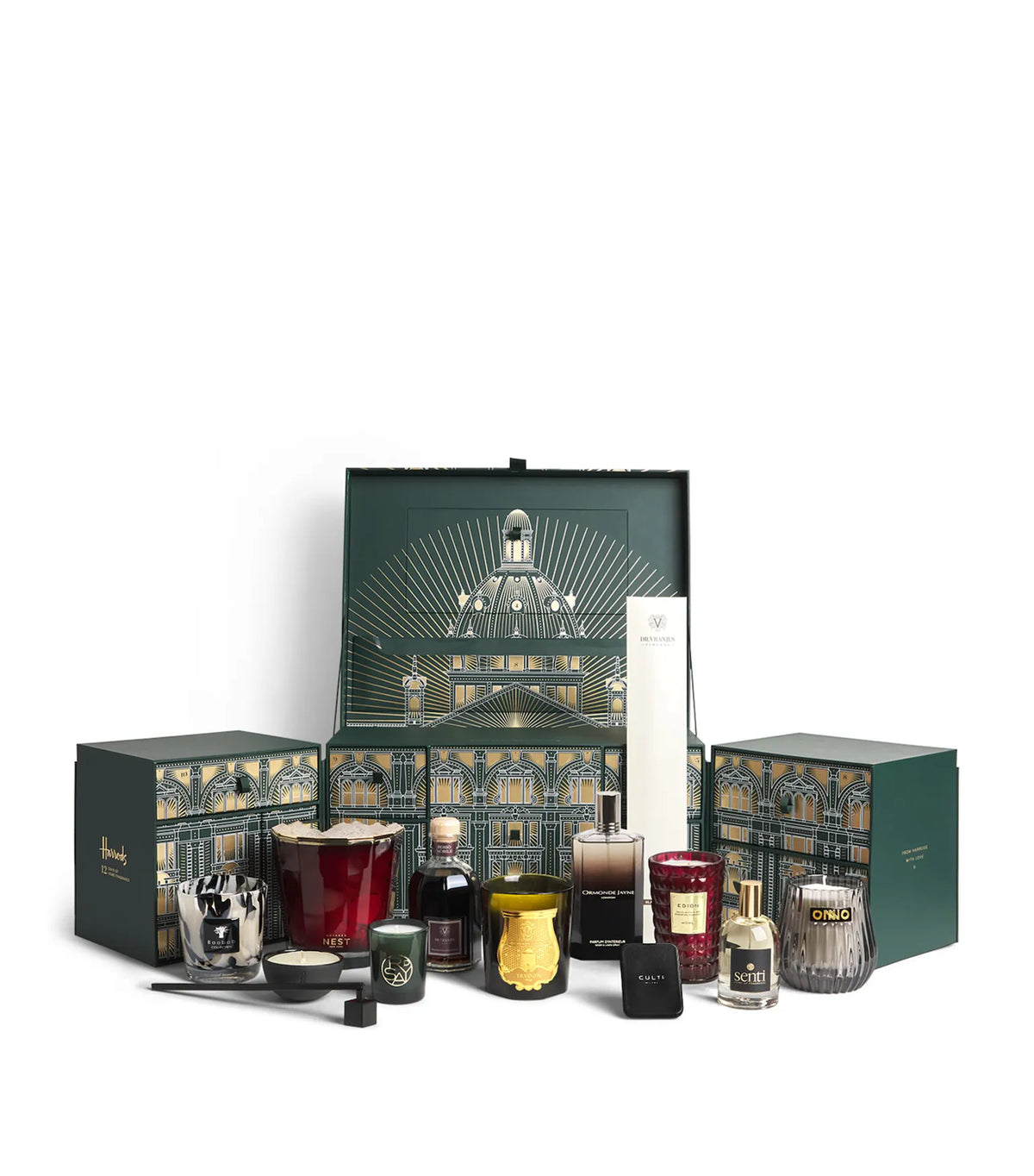 A luxury gift set featuring multiple candles in glass vessels, a white tall candle, and decorative boxes with an ornate architectural illustration. The set is arranged on a clean white background.