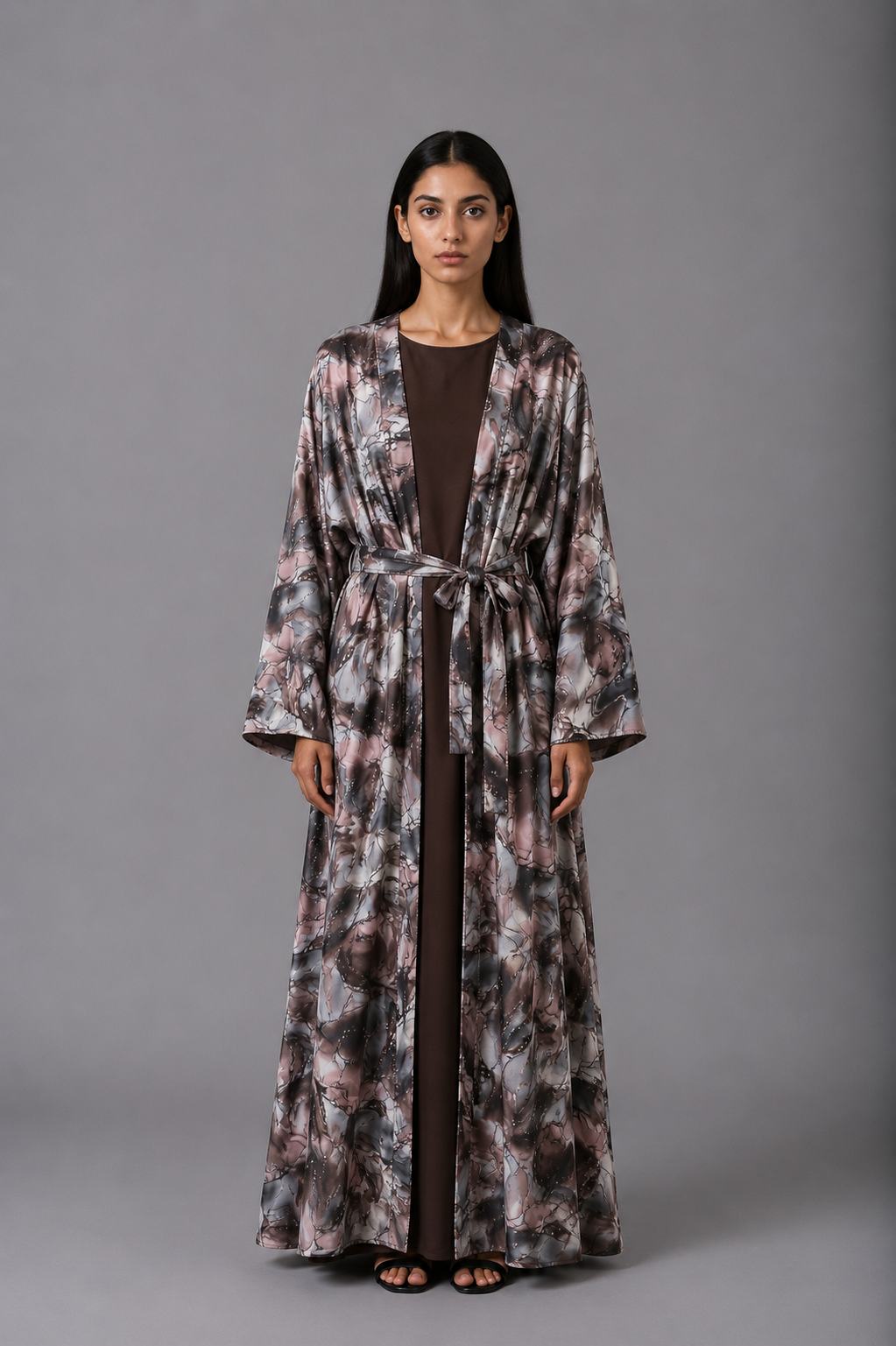 Woman wearing a long, patterned robe against a gray background