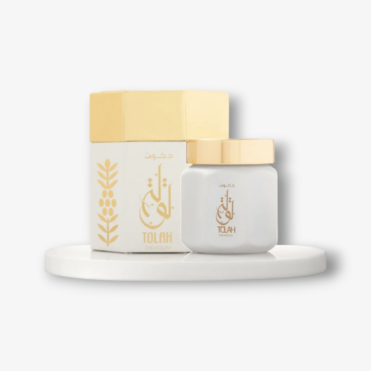 JLifestyle White Tolah Dkhoun Bakhoor incense jar and box with gold accents on a white display stand