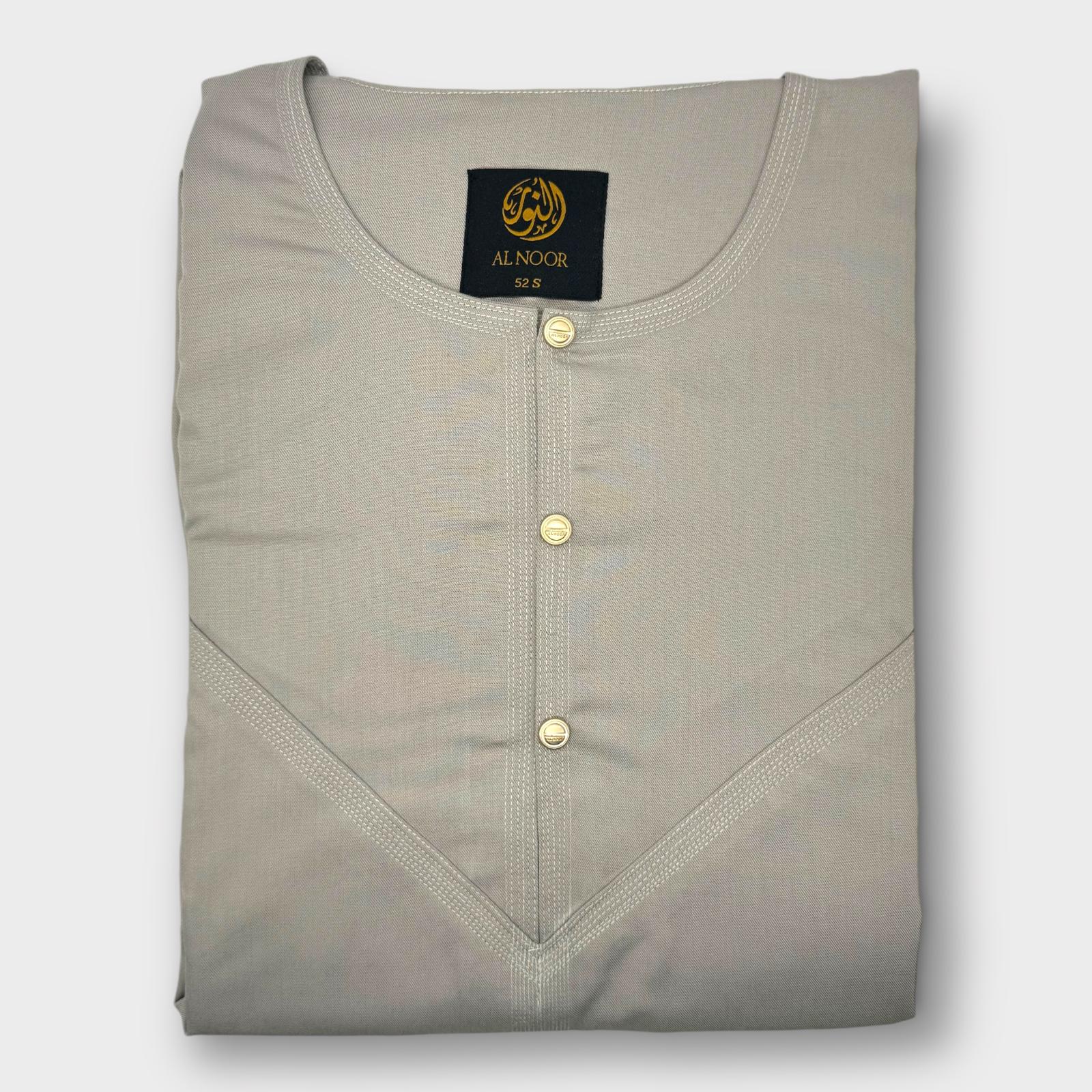 A light beige relaxed fit Omani thobe with a round neckline and two side pockets, displaying the brand label 'Al Noor' on the upper left side.