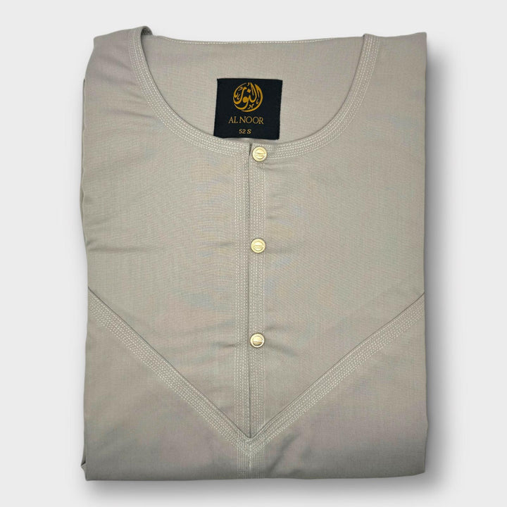 A light beige relaxed fit Omani thobe with a round neckline and two side pockets, displaying the brand label 'Al Noor' on the upper left side.