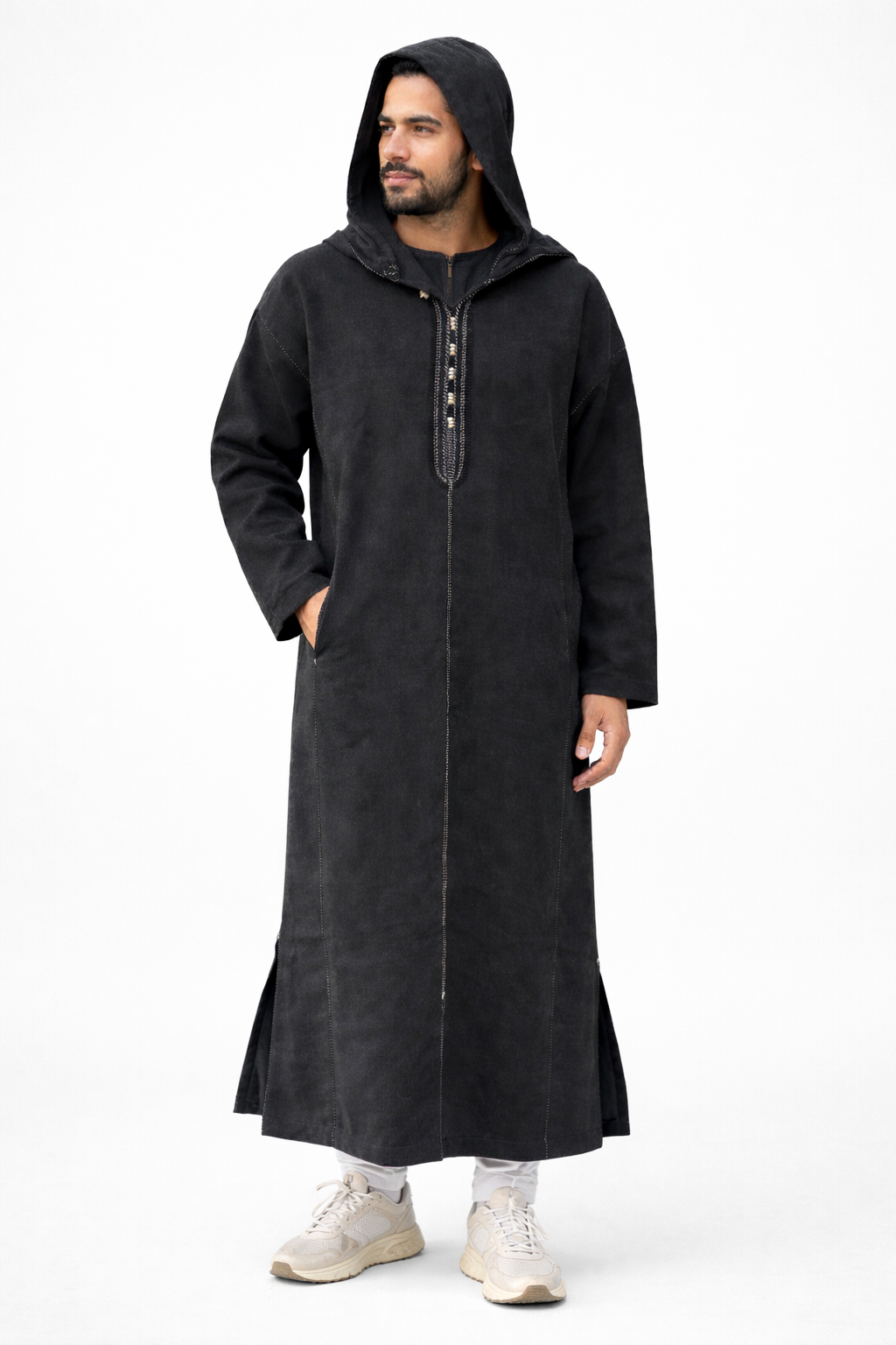 Man wearing a long black coat with a hood on a white background