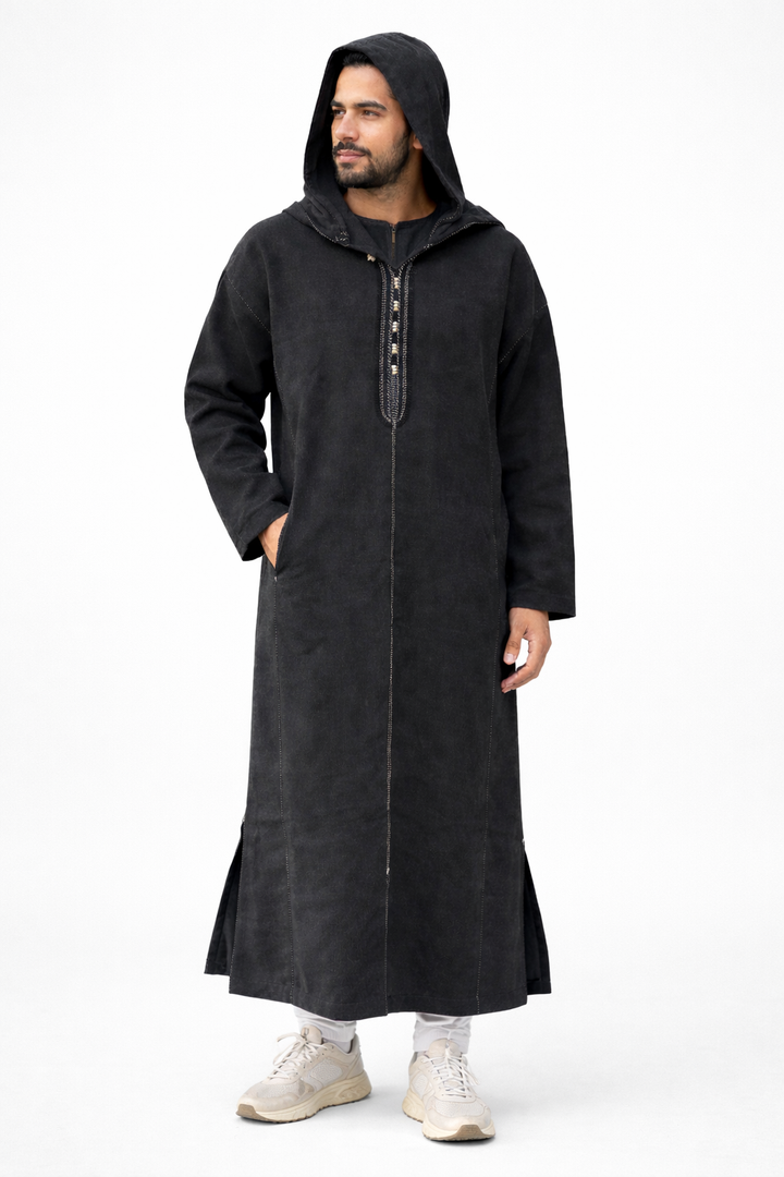 Man wearing a long black coat with a hood on a white background