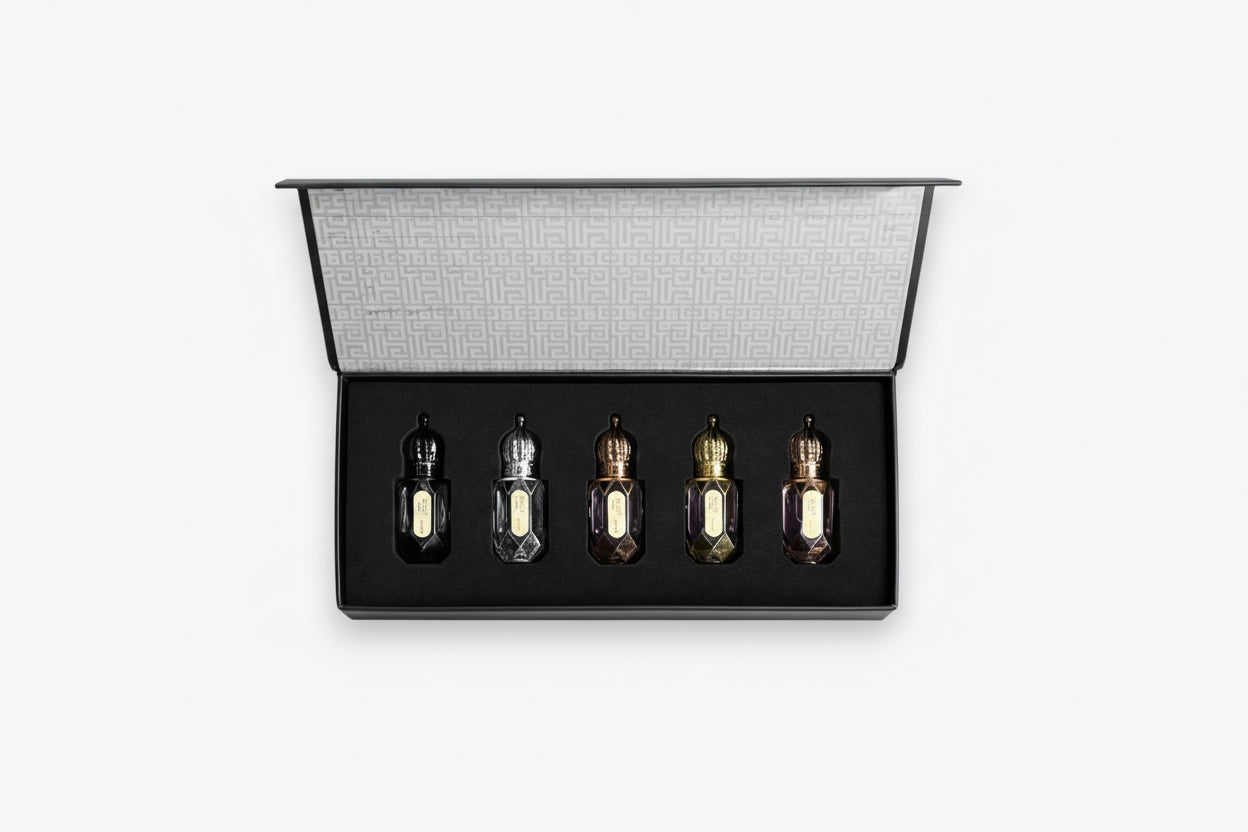Set of five small bottles in a black display case on a white background