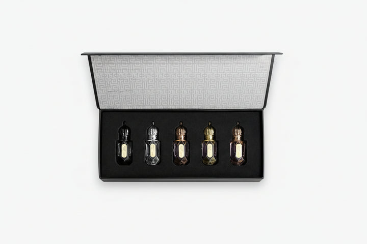 Set of five small bottles in a black display case on a white background