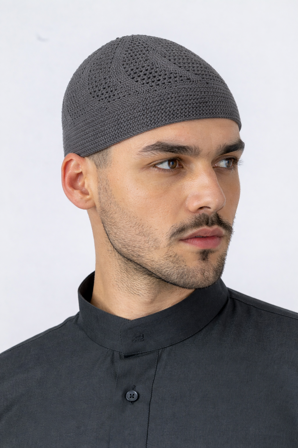 Man wearing a gray knitted cap against a white background