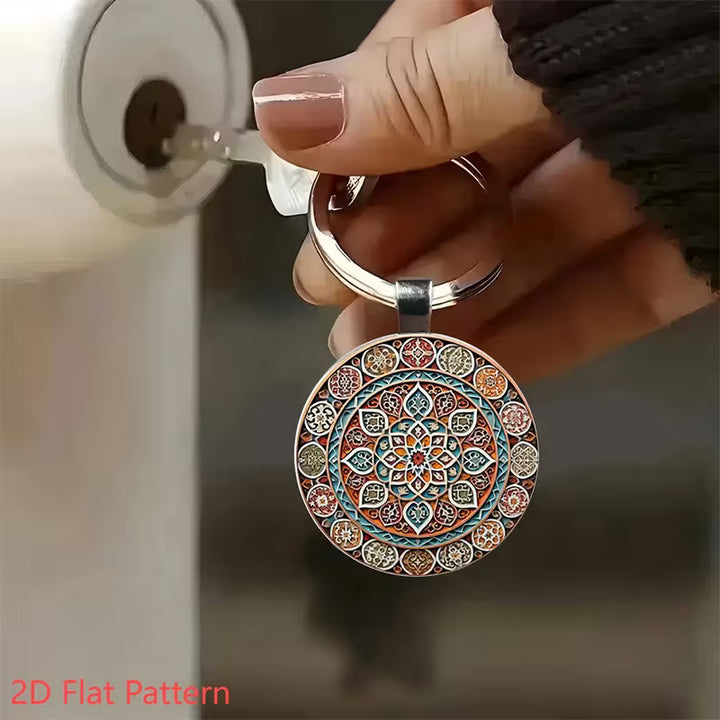 A hand holds a round metal keychain with an intricate multicolor mandala pattern. The keychain is positioned in front of a lock cylinder, suggesting its use for key replication or lock picking.